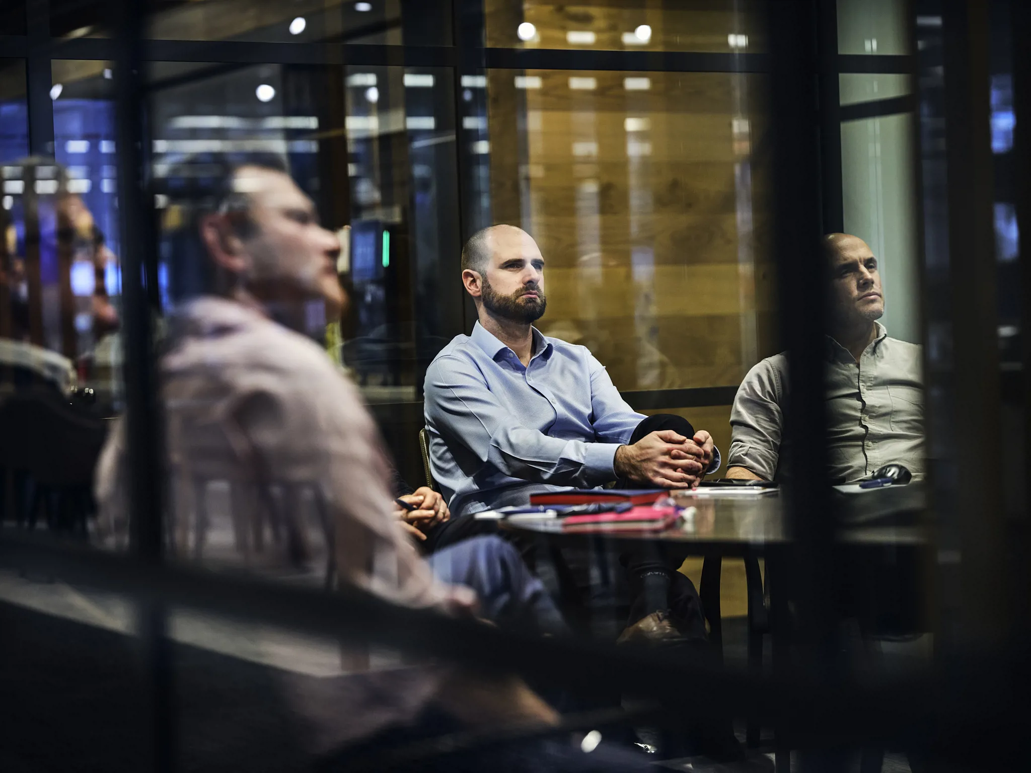 men in meeting, photographed through glass